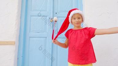 女孩<strong>红色</strong>的圣诞老人他采取自拍在户外街米克诺斯孩子街典<strong>型</strong>的希腊传统的村白色墙色彩斑斓的<strong>门</strong>米克诺斯岛希腊